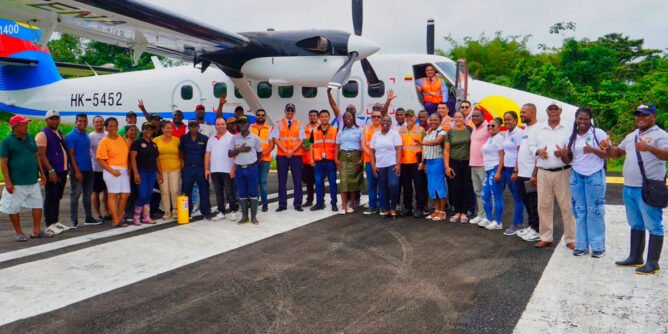 Varias personas con un avión de Satena en el aeropuerto de El Charco, Nariño